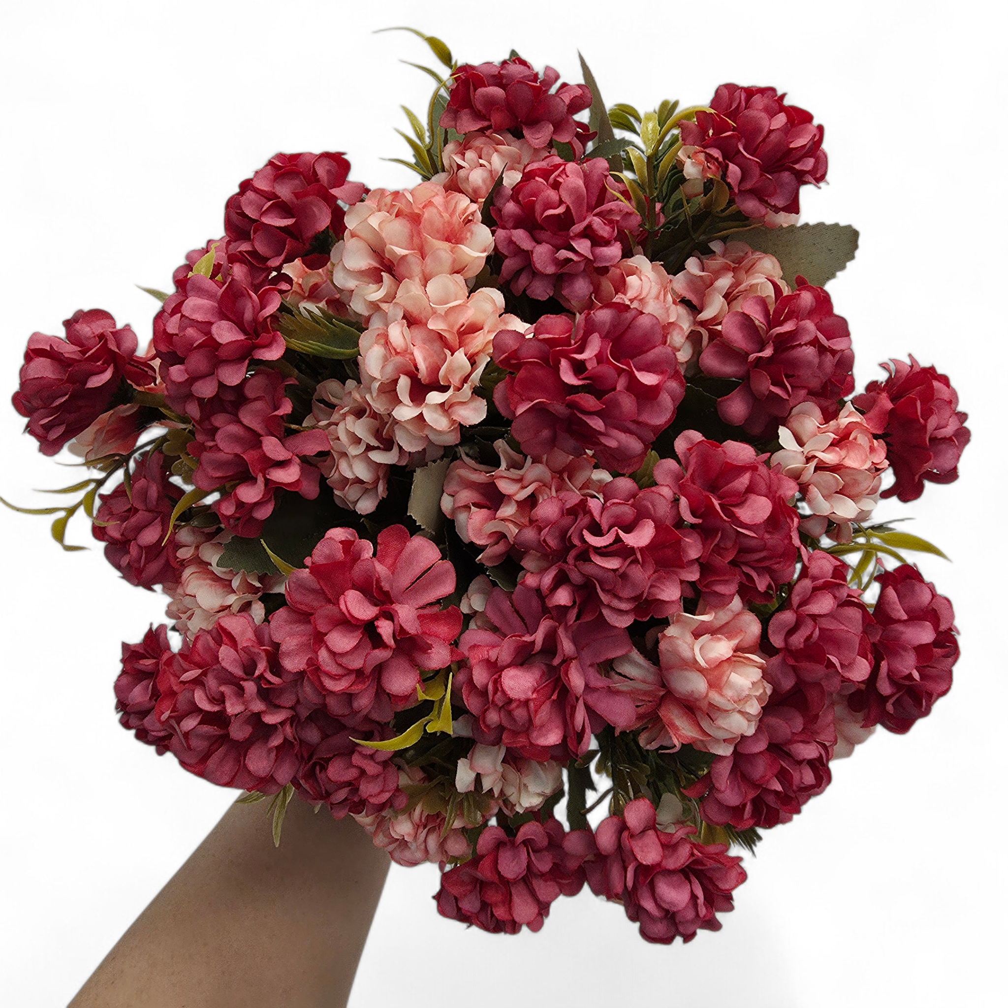 Bouquet of pink and red flowers held by a hand on a white background