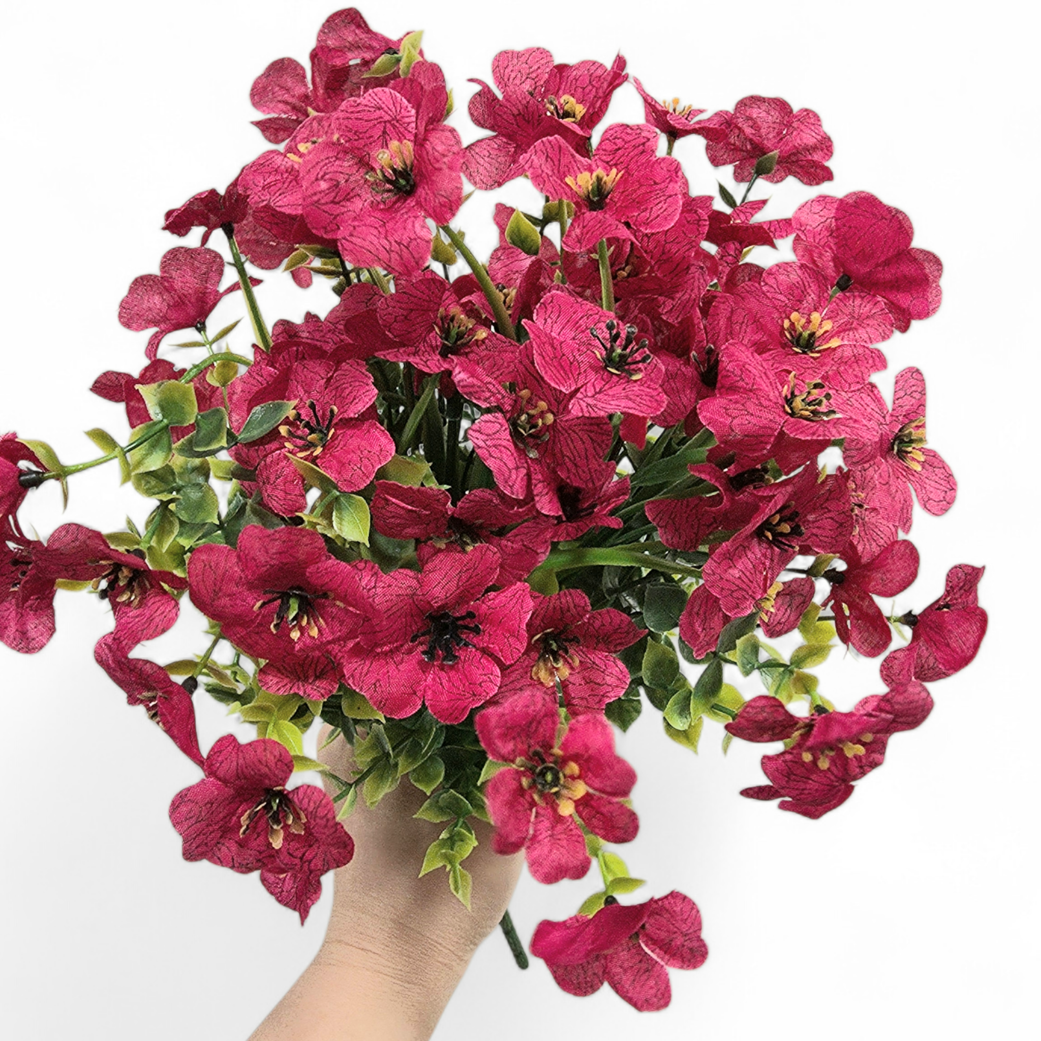 Bouquet of bright pink flowers held by a hand on a white background