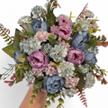 Bouquet of artificial flowers in purples and blues on a white background