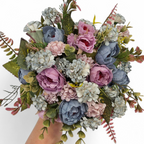 Bouquet of artificial flowers in purples and blues on a white background