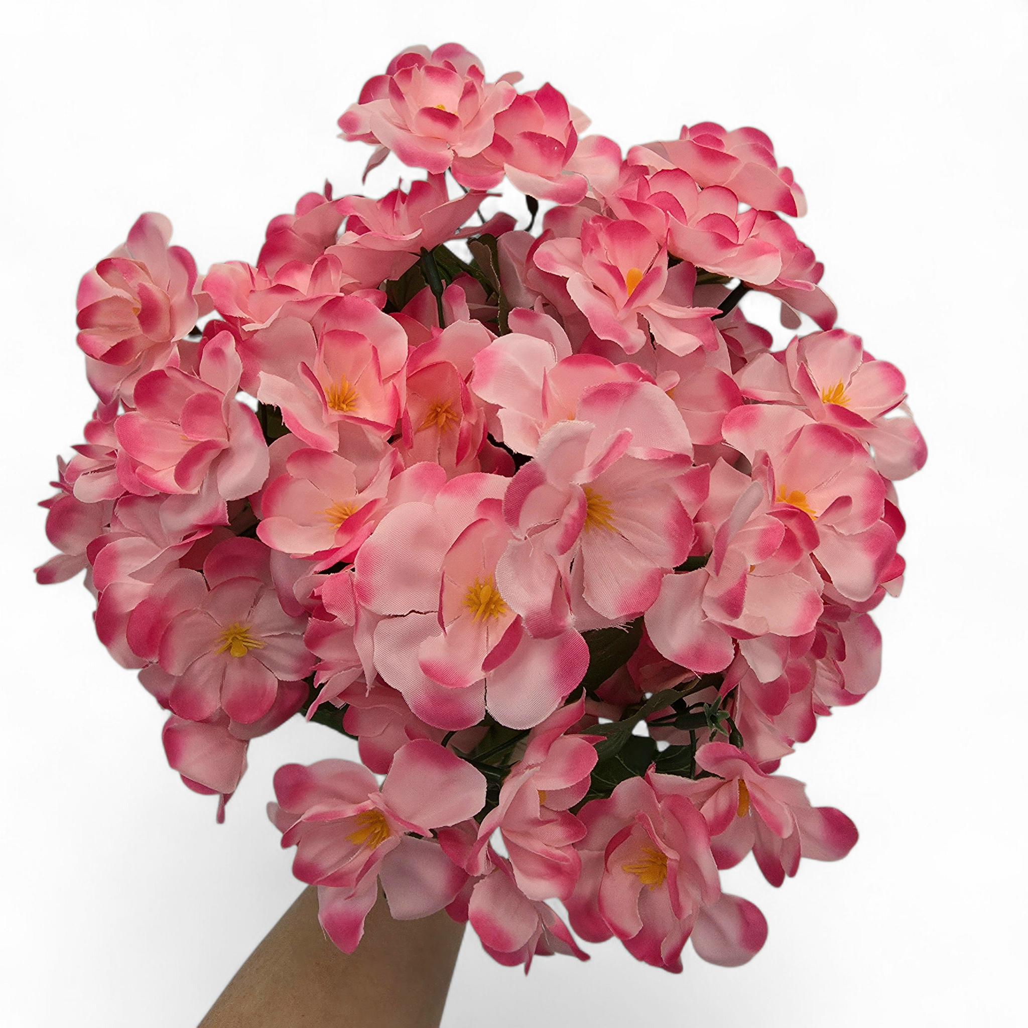 Bouquet of pink flowers held by a hand on a white background