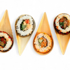 Four pieces of sushi in palm leaf spoons on a white background