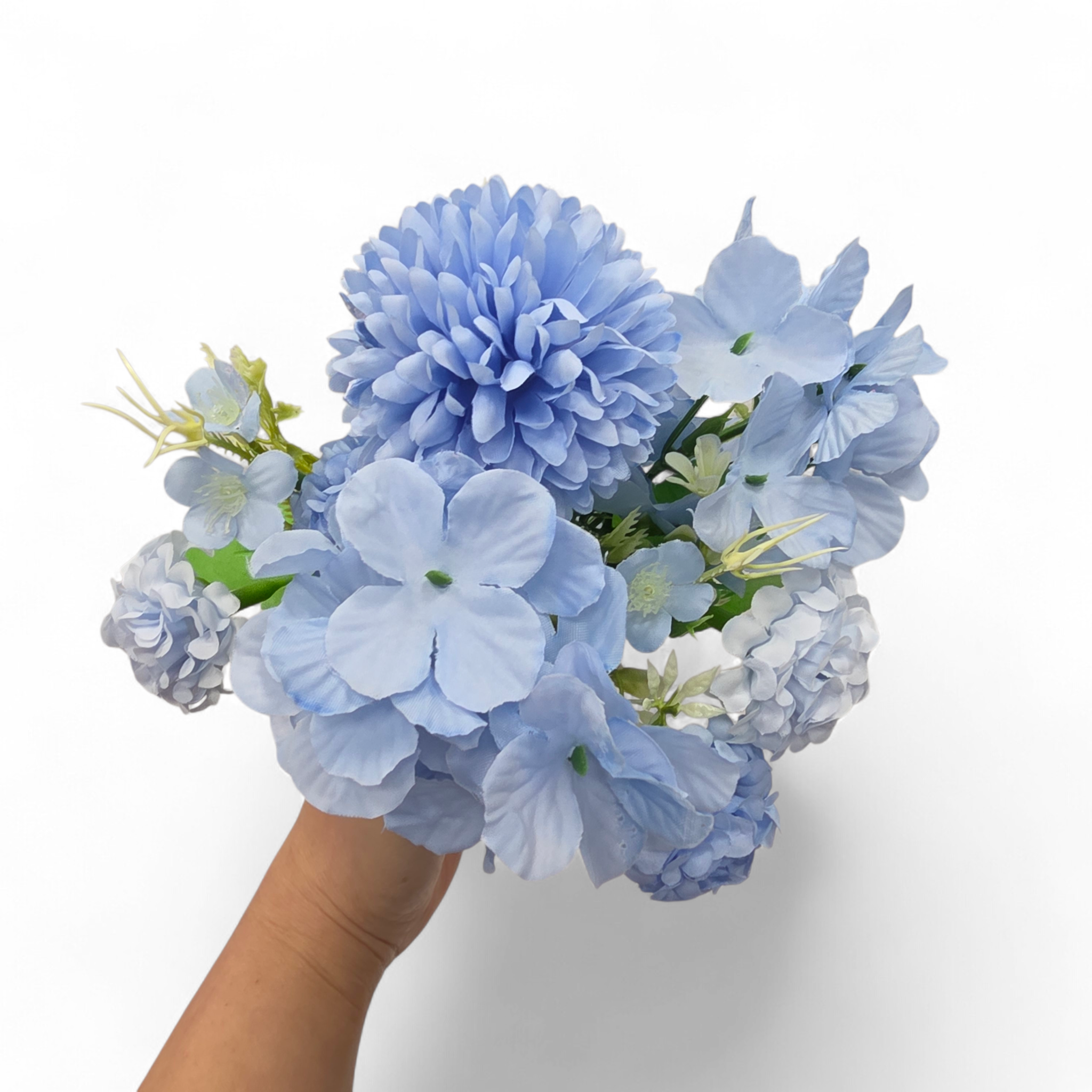 Bouquet of blue flowers held by a hand against a white background