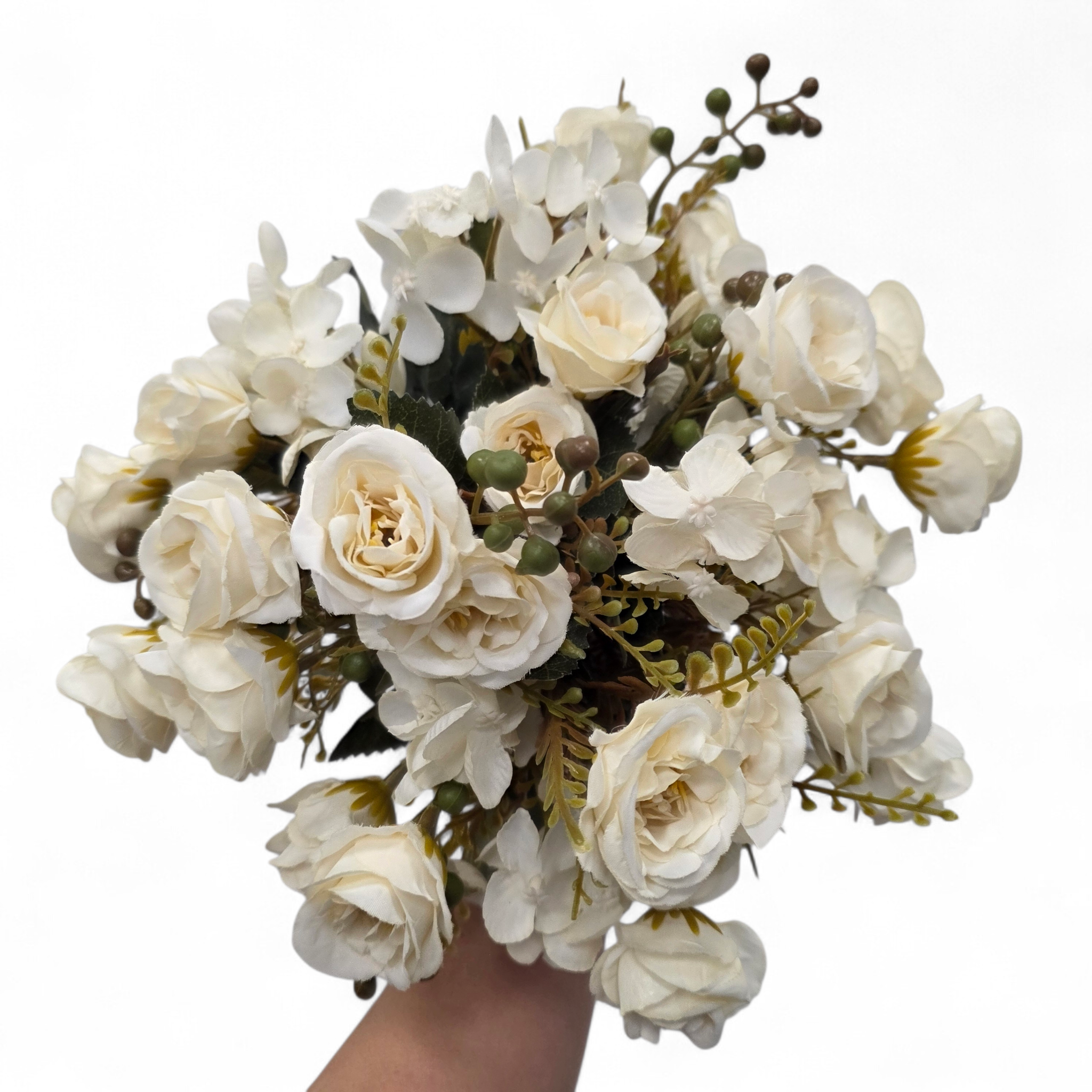 Bouquet of ivory white flowers held by a hand on a white background