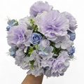 Bouquet of lavender and blue flowers held by a hand on a white background
