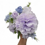 Bouquet of lavender and white flowers held by a hand on a white background
