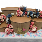 Decorative setup with grazing table kit, flowers, and 'Girl or Boy' sign on a table with gender reveal confetti.