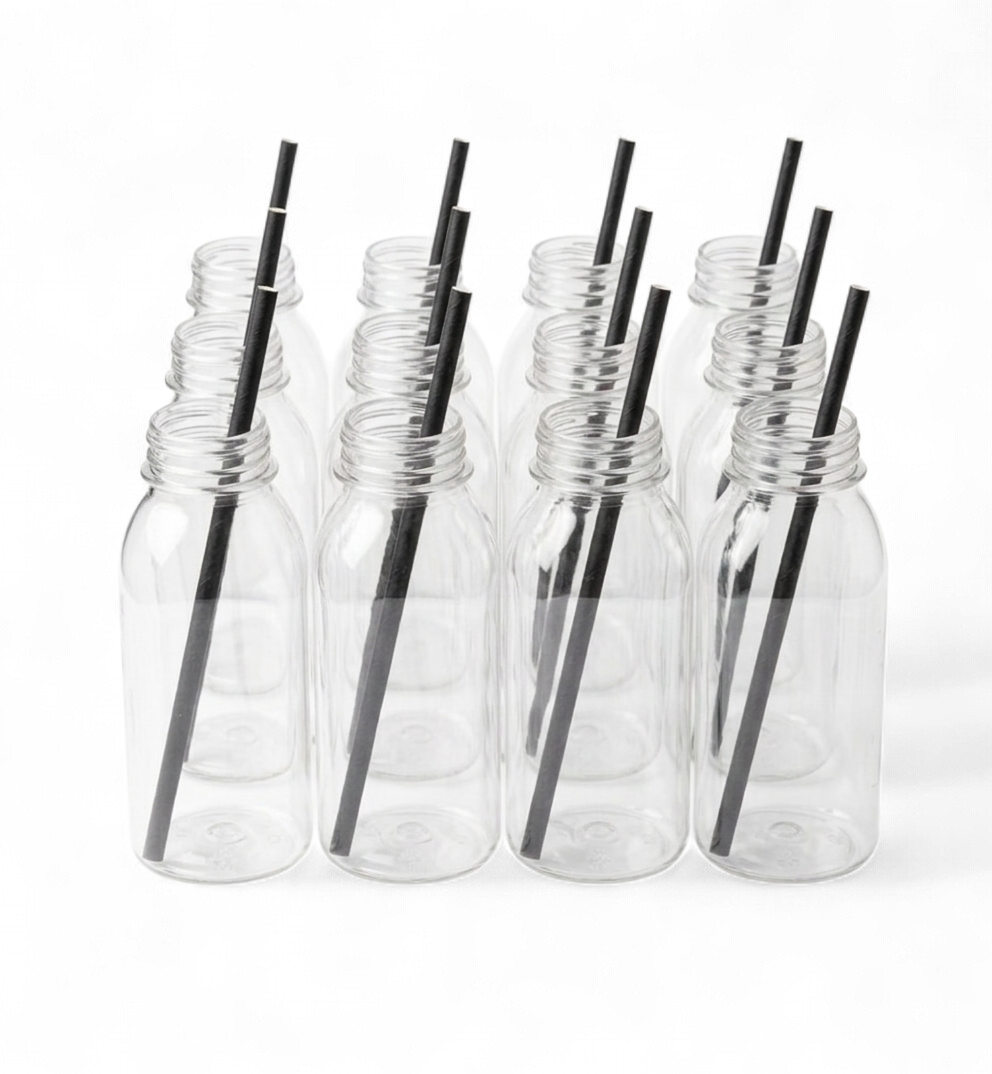 Clear plastic bottles with black straws on a white background
