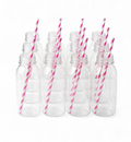 Set of clear plastic bottles with hot pink and white striped straws on a white background