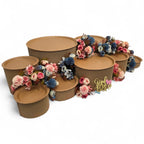 DIY grazing table kit baby shower gender reveal with disposable natural platters plinths, pink and blue flowers, baby footprint confetti and a "girl or boy?" sign left front view - grazekits